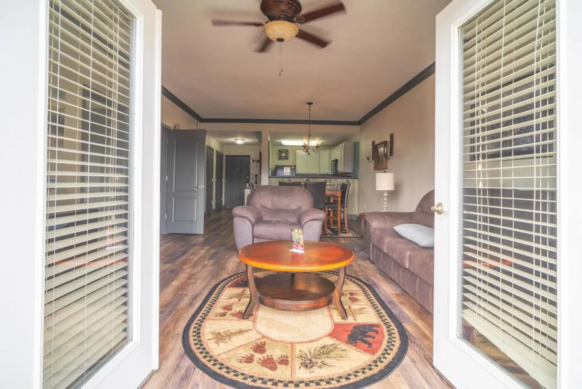A bright, inviting seating area featuring comfortable chairs, a coffee table, and a rug with a nature motif. The space feels airy, perfect for planning the next adventure or sharing stories from the day.