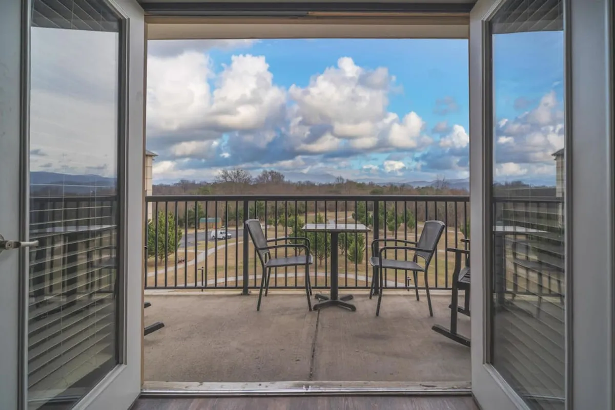This exterior image showcases a balcony with comfortable chairs overlooking a scenic landscape under a cloudy sky. The setting suggests quiet moments of relaxation, socializing, and enjoying the view—ideal for small gatherings or unwinding after a day of adventure.